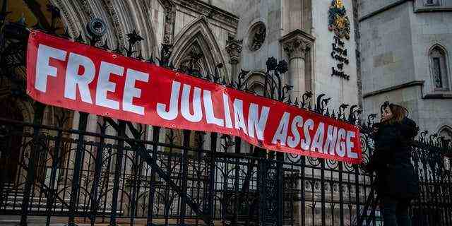 Ein Anhänger von Julian Assange hängt am 10. Dezember 2021 in London, England, ein Transparent vor den Royal Courts of Justice auf.  (Foto von Chris J. Ratcliffe/Getty Images)