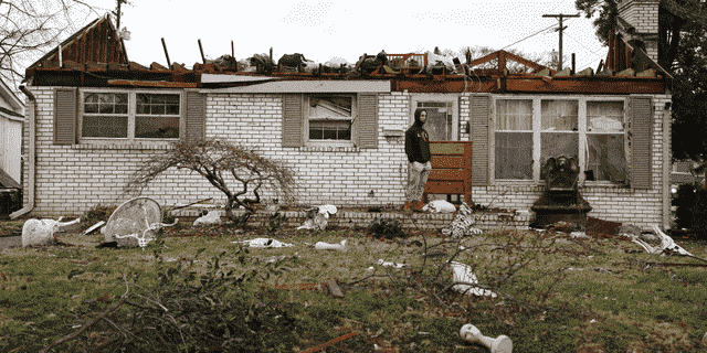 TOPSHOT – Ein Einwohner von Bowling Green, Kentucky, begutachtet die Schäden nach einem Tornado, der das Gebiet am 11. Dezember 2021 traf Lager in Illinois, das gelitten hat "katastrophaler Schaden" mit rund 100 Menschen darin eingeschlossen.  Die Stadt Mayfield im Westen von Kentucky war "Ground Zero" des Sturms – eine Szene von "massive Verwüstung," sagte ein Beamter.  (Foto von Gunnar Word / AFP) (Foto von GUNNAR WORD / AFP über Getty Images)