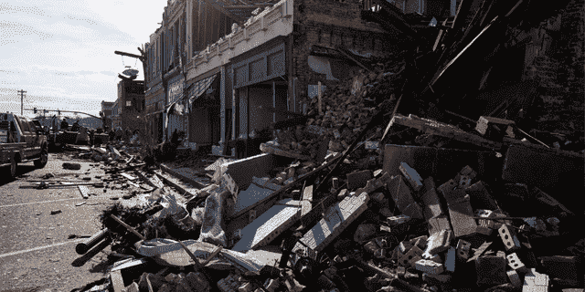 Trümmer von einem Tornado-beschädigten eingestürzten Gebäude türmen sich am 11. Dezember 2021 in Mayfield, Kentucky, auf die Straße. 