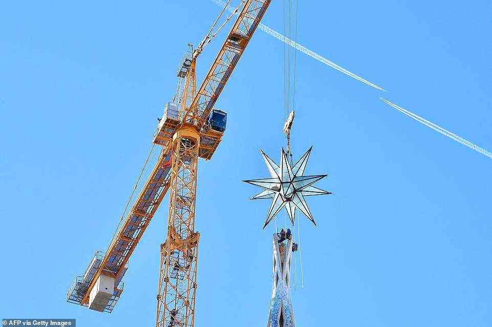 Pictured is the installation of the 5.5-tonne, 12-pointed glass star atop the Virgin Mary tower in late November