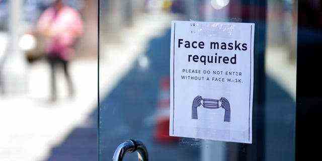 Ein Schild rät Käufern, am Montag, den 19. Juli 2021, im Stadtteil Fairfax von Los Angeles außerhalb einer Geschichte Masken zu tragen.  (AP Foto/Marcio Jose Sanchez)