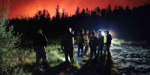 DATEI – Feuerwehrleute und Freiwillige haben eine Einweisung, während sie am Ort des Waldbrands im Gebiet Gorny Ulus westlich von Jakutsk in Russland arbeiten, Samstag, 7. August 2021. (AP Photo/Ivan Nikiforov, Datei)