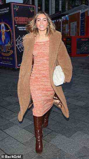 Glamourgirl: Frankie machte in einem figurbetonten orangefarbenen Kleid eine stylische Figur, während sie am Mittwoch in London in einen kuscheligen braunen Lammfellmantel gehüllt war