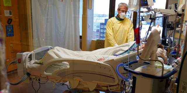 Steve Grove, ein Kaplan im Hennepin County Medical Center, betet am Freitag, den 10. Dezember 2021, in Minneapolis im Zimmer eines COVID-19-Patienten. 