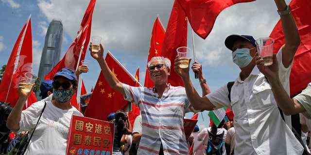 Pro-China-Anhänger, die chinesische Nationalflaggen halten, stoßen während einer Kundgebung an, um die Verabschiedung eines nationalen Sicherheitsgesetzes für Hongkong in Hongkong zu feiern.