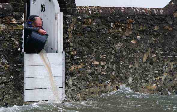 Ein Mann beschäftigt sich nach Sturm Barra . mit einem überfluteten Haus