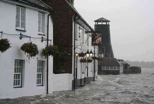 Meerwasser überschwemmt die Küstenlinie vor dem Royal Oak Pub nach Flut in Langstone, Hampshire