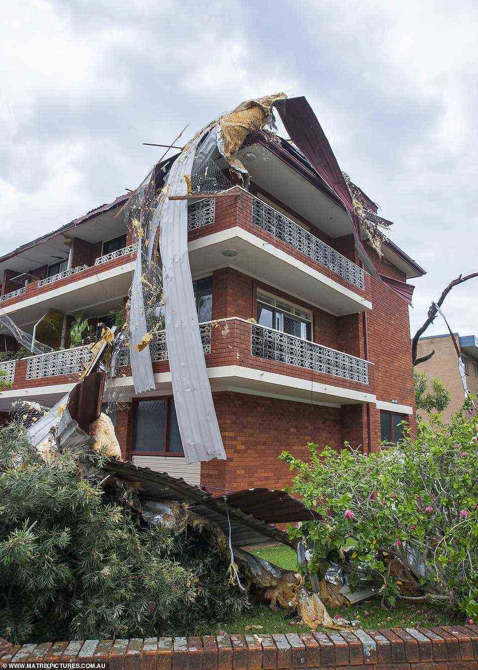 A Northern Beaches apartment building had its roof ripped off and carried away by a 'mini tornado' as a freak five-minute storm swept over the city