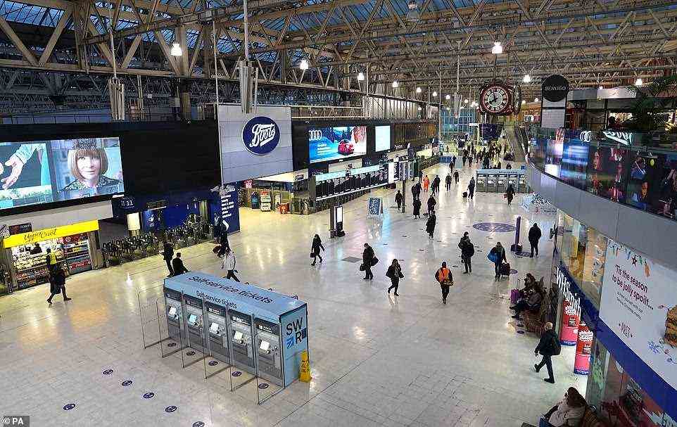 Commuters pass through London Waterloo train station at about 8am today as the Omicron Covid variant surges