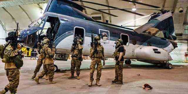 31. AUGUST 2021: Taliban-Kämpfer mit von Amerika gelieferten Waffen, Ausrüstung und Uniformen auf dem internationalen Flughafen von Kabul.  (MARCUS YAM / LOS ANGELES TIMES)