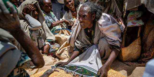 Eine Äthiopierin streitet mit anderen über die Verteilung von gelben Erbsen, die die Frauenhilfsvereinigung von Tigray am 8. Mai 2021 in der Stadt Agula in der Region Tigray im Norden Äthiopiens verteilt dass die Leute hungern;  Es ist so, dass viele hungern, fand The Associated Press. 