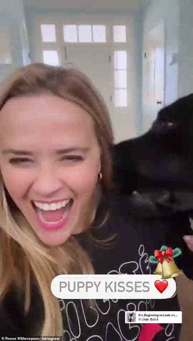 Kisses: Reese Witherspoon seemed to be in great spirits with her Christmas Eve post as she posed with her black dog. The Wild actress was seen at home as she showed off some of her decorations