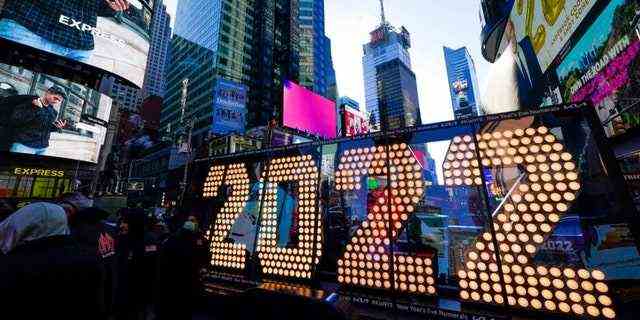 Das 2022-Schild, das am Silvesterabend auf einem Gebäude beleuchtet wird, wird am Montag, den 20. Dezember 2021 auf dem Times Square in New York ausgestellt. Auch dieses Jahr werden Menschenmassen den New Yorker Times Square mit Beweisen für COVID-19-Impfung für Nachtschwärmer erforderlich, die den Ball persönlich fallen sehen möchten, kündigte Bürgermeister Bill de Blasio letzte Woche an.