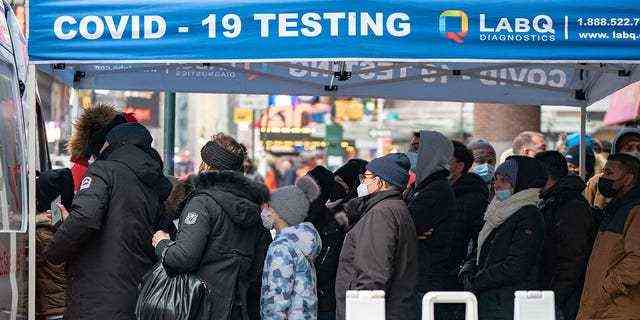 Die Menschen stehen an einer Popup-COVID-19-Teststelle Schlange, während sich die Omicron-Coronavirus-Variante am 27. Dezember 2021 in Manhattan, New York City, weiter verbreitet. 