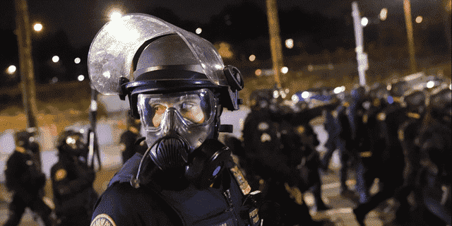 Ein Polizist aus Portland, Oregon, scannt die Menge, während er Demonstranten am 21. August 2020 zerstreut. 