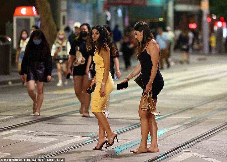 A glamourous reveller ditched her high heel shoes after a long night of partying in Sydney's Circular Quay