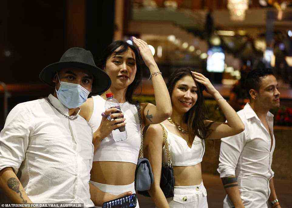 All white on the night: Sydney revellers dressed to stay cool in the city on New Year's Eve on a night of partying
