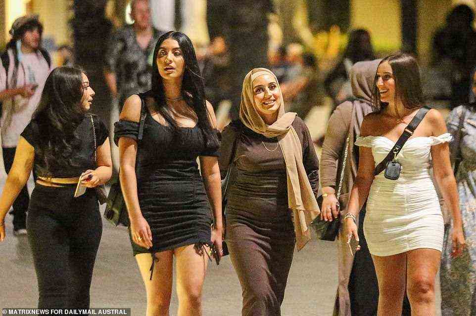 Friends walk through St Kilda after celebrating New Year's Eve in Melbourne after a hot day