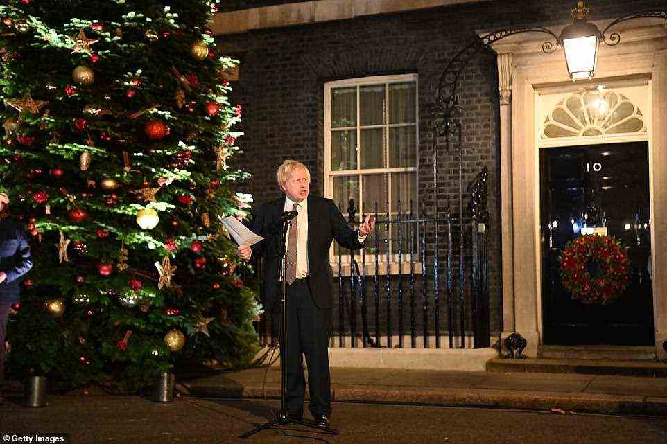 Boris Johnson pictured making a speech as he visits a UK Food and Drinks market set up in Downing Street today. He urged people not to cancel Christmas parties or school nativity plays as he promised to 'throw everything' at the booster vaccination campaign to tackle the spread of the Omicron coronavirus variant