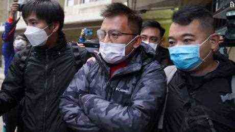 Leitender Redakteur von "Stand News"  Ronson Chan, Mitte, wird am Mittwoch, 29. Dezember 2021, in Hongkong von Polizisten abgeführt. 