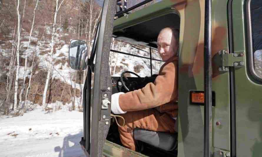 Putin am Steuer eines Geländewagens während einer Fahrt im russischen Föderalen Bezirk Sibirien im März