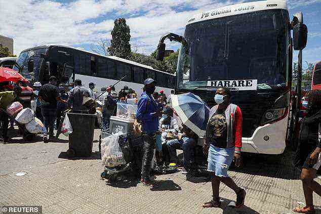 Passagiere besteigen Busse, die am 14. Dezember in Johannesburg, Südafrika, nach Simbabwe reisen, inmitten der Verbreitung der Omicron-Variante