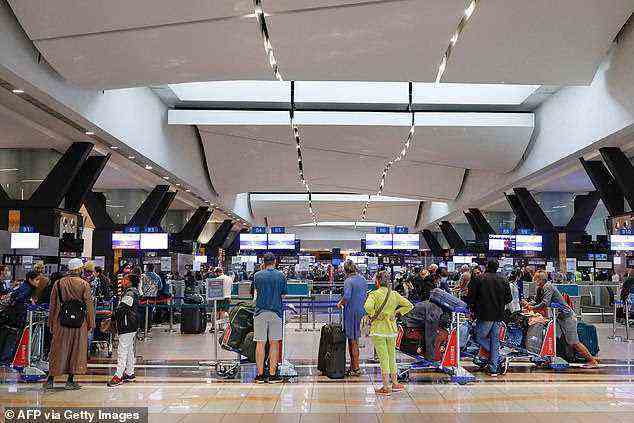 Reisende stehen am 27. November am OR Tambo International Airport in Johannesburg an, nachdem mehrere Länder nach der Entdeckung von Omicron . Flüge aus Südafrika verboten hatten