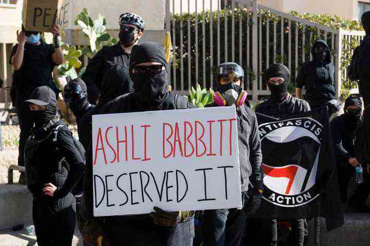 Counter-protesters hold a sign reading "Ashli Babbitt deserved it" as they await demonstrators for a "Patriot March" demonstration in support of President Donald Trump on January 9, 2021 in San Diego, California.