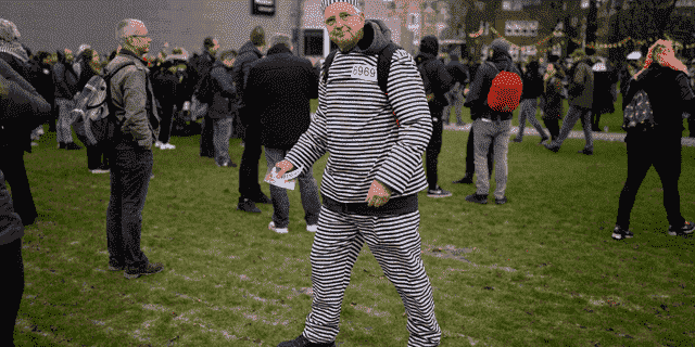 Ein Mann, der einen Gefangenenanzug trug, schloss sich Hunderten von Menschen an, die sich am Sonntag einem Verbot widersetzten, um sich am Sonntag, den 2. Januar 2022, in Amsterdam, Niederlande, gegen die Coronavirus-Sperrmaßnahmen der niederländischen Regierung zu versammeln und zu protestieren. (AP Photo/Peter Dejong)