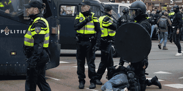Die Polizei verhaftet einen Demonstranten, als sich am Sonntag, den 2. Januar 2022, in Amsterdam, Niederlande, Tausende von Menschen einem Verbot widersetzten, um sich gegen die Coronavirus-Sperrmaßnahmen der niederländischen Regierung zu versammeln und zu protestieren. (AP Photo/Peter Dejong)