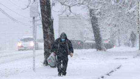 Eine Person geht den Bürgersteig in Alexandria, Virginia, entlang, als am Montag ein Winterschneesturm die Region Nord-Virginia traf.