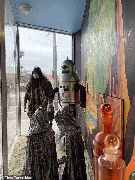 Das oben abgebildete Schaufenster des Ladens zeigt einen in Pelze gekleideten Höhlenmenschen und einen futuristischen silbernen Roboter