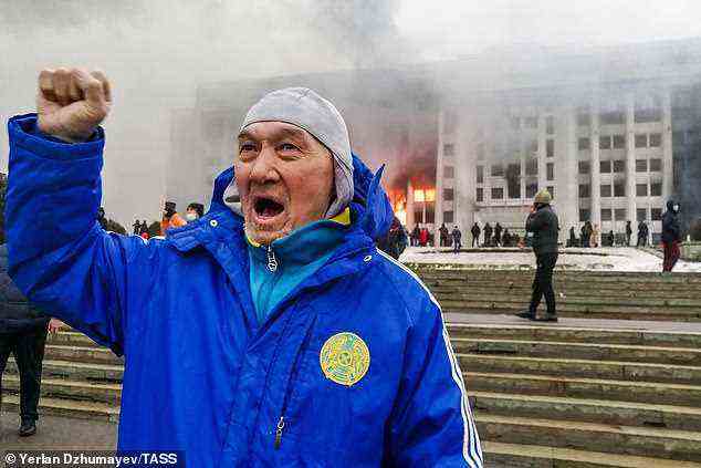 Ein Mann versammelt sich vor dem brennenden Bürgermeisteramt.  In ganz Kasachstan breiten sich Proteste gegen die steigenden Treibstoffpreise aus;  Demonstranten brachen in das Büro des Bürgermeisters von Almaty ein und zündeten es an