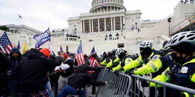 Trump-Anhänger versuchen am Mittwoch, 6. Januar 2021, im Kapitol in Washington eine Polizeisperre zu durchbrechen.  (AP-Foto/Julio Cortez)