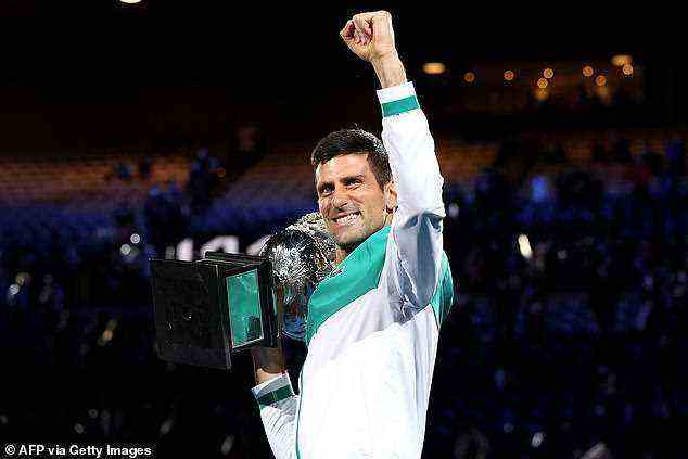 Serbia's Novak Djokovic celebrates with the Norman Brookes Challenge Cup trophy after beating Russia's Daniil Medvedev to win their men's singles final match on day fourteen of the Australian Open tennis tournament in Melbourne in 2021