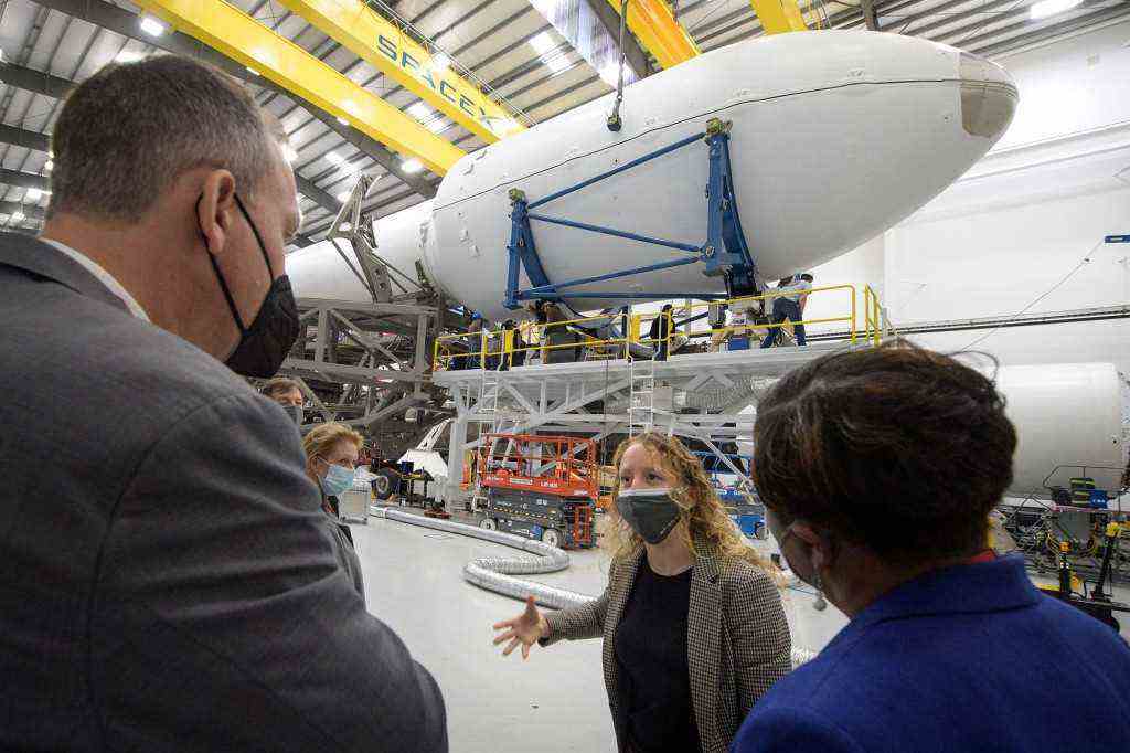 NASA Associate Administrator für das Science Mission Directorate Thomas Zurbuchen, links, und andere NASA-Führungskräfte hören zu, wie Julianna Scheiman, Direktorin für zivile Satellitenmissionen bei SpaceX, Mitte, durch den Hangar führt, in dem die Falcon 9-Rakete und die DART-Raumsonde vorbereitet werden Start auf der Vandenberg Space Force Base in Kalifornien. 