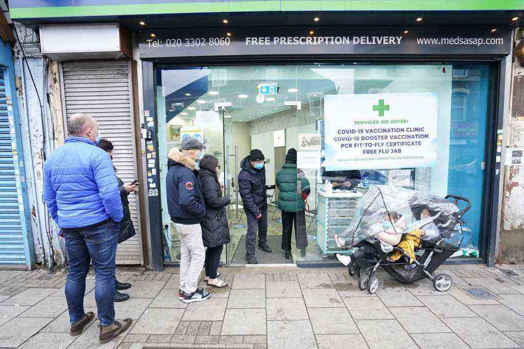 Die Leute warten in der Good Health Pharmacy im Norden Londons in der Schlange, um eine Auffrischungsimpfung 
