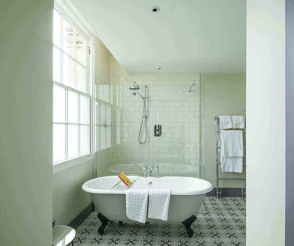 Cotswold-Klassiker: Abgebildet ist eines der großen Badezimmer mit freistehender Badewanne und flauschigen weißen Handtüchern