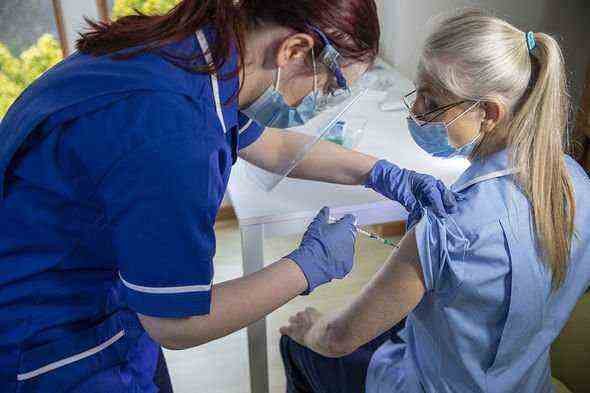 Krankenschwester, die Krankenschwester Covid-Impfstoff gibt