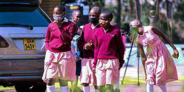 Schülerinnen und Schüler laufen während der Pausenzeiten der Kitante Primary School in Kampala, Uganda, am Montag, den 10. Januar 2022, auf dem Schulgelände herum. 