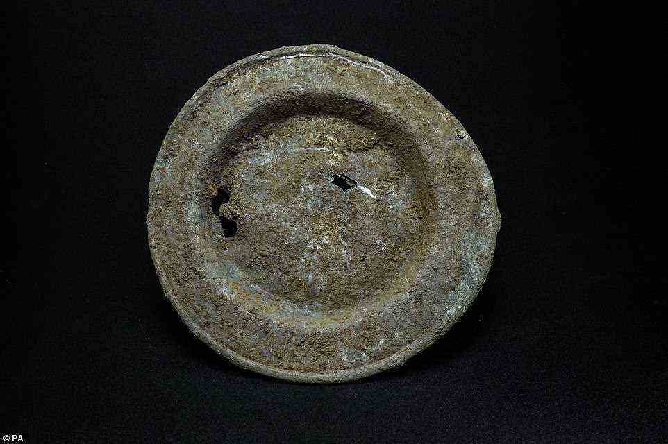A Pewter plate. In one part of the site, the earth is bright red, suggesting the area would have been used for activities involving burning, such as bread-making, foundries for metal work or a kiln