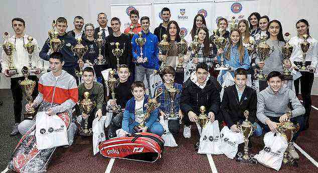 On December 16, Djokovic (pictured centre at the back) posed with dozens of children at a PR event with the Tennis Association of Belgrade, the day after the purported positive PCR test