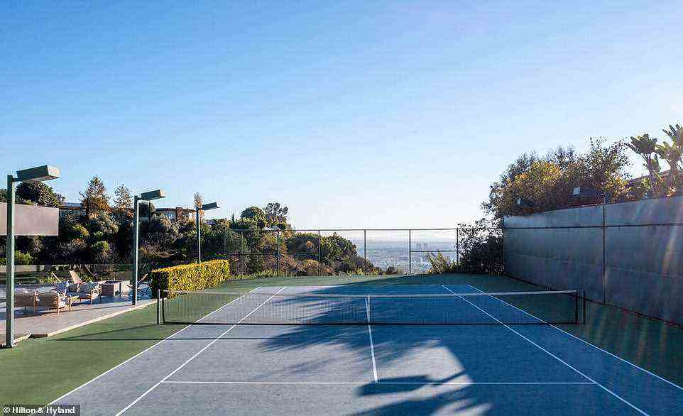 Sports fan: The property includes a full-size tennis court to the side of the pool area