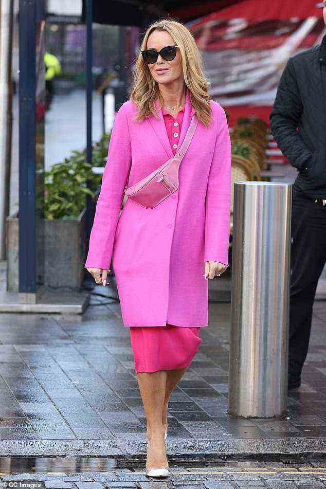 Stunner: Sie trug ein eng anliegendes Strickkleid in einem leuchtenden Pink mit einem warmen Mantel, der in einem kontrastierenden - aber dennoch makellos gepaarten - Pinkton darüber geschichtet war