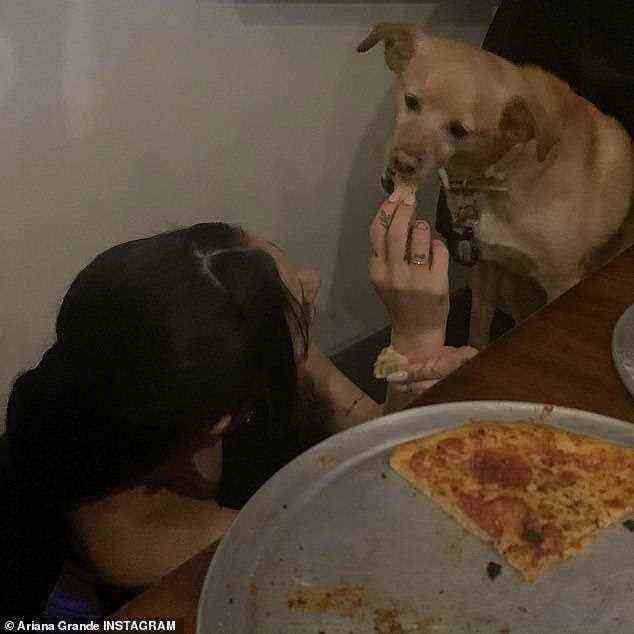 Sängerin Ariana Grande teilt in einem Instagram-Post ein bisschen Pizza mit einem ihrer Schoßhunde