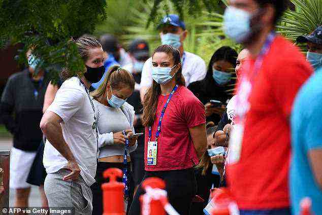 Tennis player Maria Sakkari of Greece (centre) waits with fellow players and officials outside a hotel for a Covid-19 coronavirus test in Melbourne on February 4, 2021. For this year's Australian Open, players, staff and the media will have to take a rapid antigen test every day