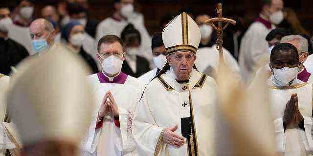 Papst Franziskus geht mit seinem pastoralen Stab zwischen Kardinälen und Prälaten mit FFP2-Masken am Ende einer Dreikönigsmesse im Petersdom im Vatikan, Donnerstag, 6. Januar 2022. 