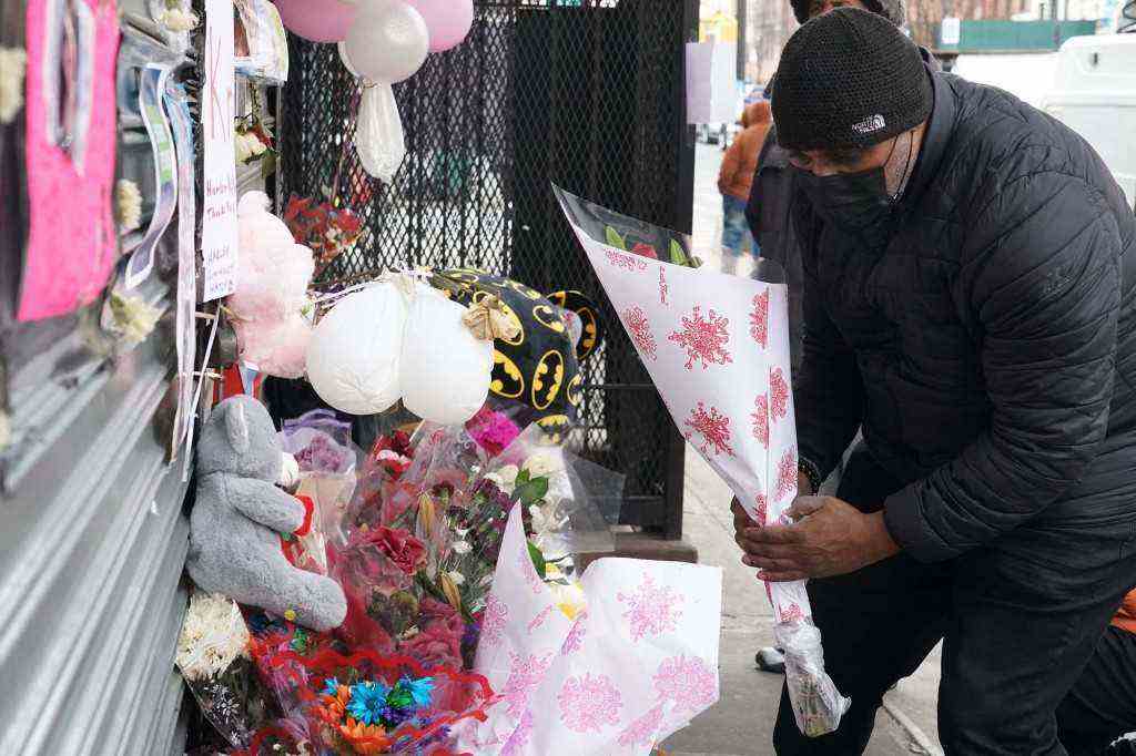 Eine Person legt Blumen am Denkmal für Krystal Bayron-Nieves nieder.
