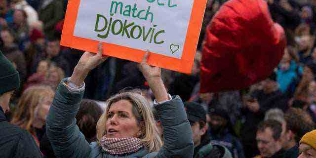 Eine Frau hält eine Botschaft für Novak Djokovic aus Serbien, als Tausende von Menschen am Sonntag, den 16. Januar 2022 in Amsterdam, Niederlande, gegen die Coronavirus-Sperrmaßnahmen der niederländischen Regierung protestierten. (AP Photo/Peter Dejong)