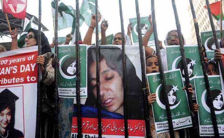 Pakistanische Demonstranten der sunnitischen Hardliner-Gruppe Pasban halten Porträts der pakistanischen Wissenschaftlerin Aafia Siddiqui während einer Demonstration zum Internationalen Frauentag am 8. März 2011. Siddiqui wurde von einem US-Gericht, das sie des versuchten Mordes für schuldig befand, zu 86 Jahren Gefängnis verurteilt der US-Militäroffiziere in Afghanistan im Jahr 2008.